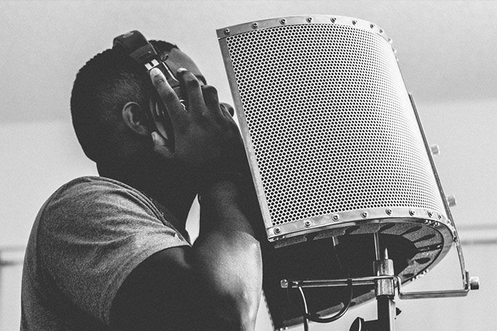 man recording in isolation shield