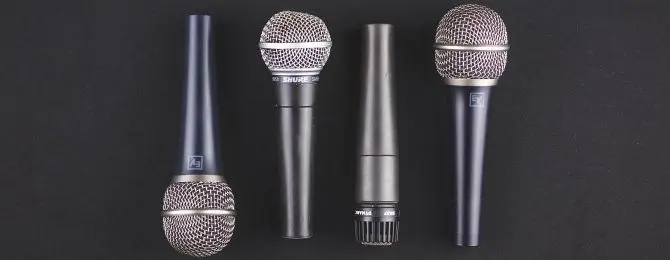 microphones-laidout various dynamic microphones lined up beside eachother on a black background
